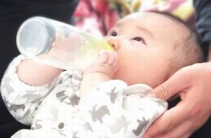哺乳瓶でミルクを自分で飲む赤ちゃん